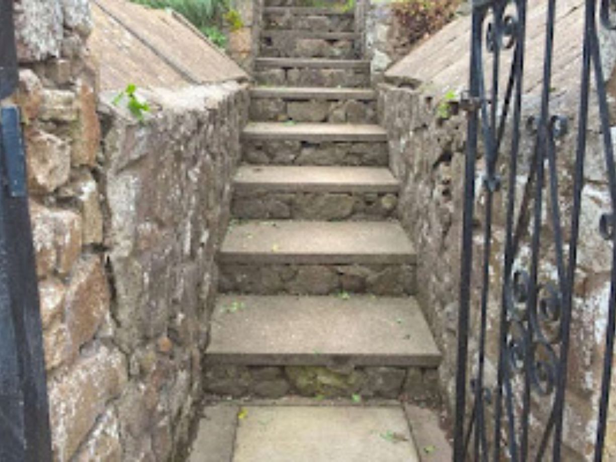 laying cement into a wall trench as the base foundaion for a cobbel stonewall